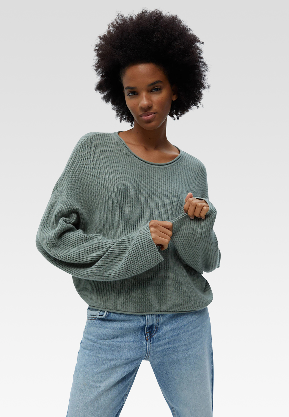 a dark skinned woman in greenish jumper
